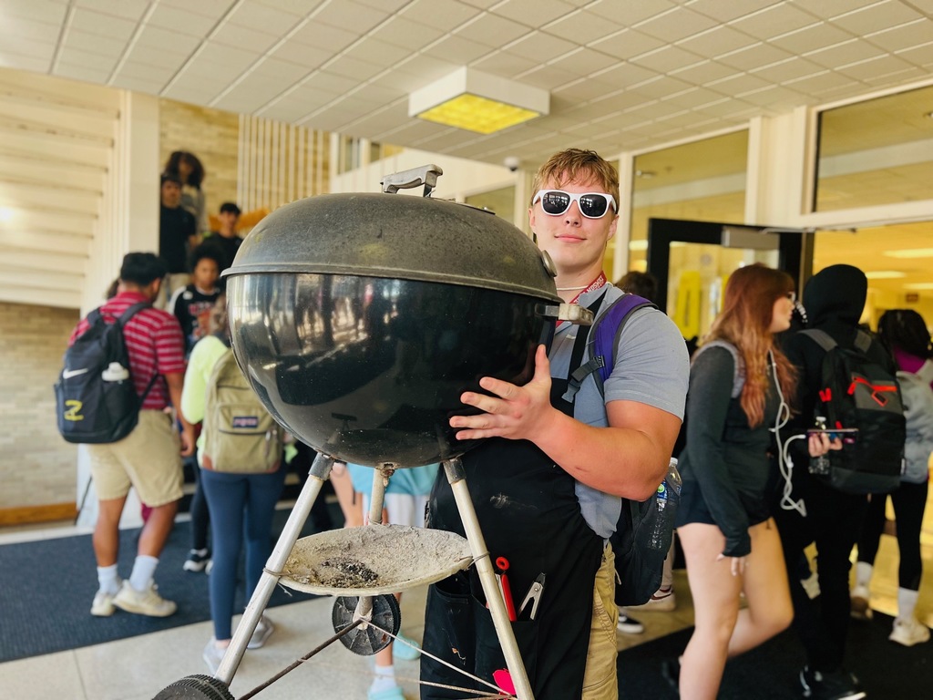 Student carrying a grill
